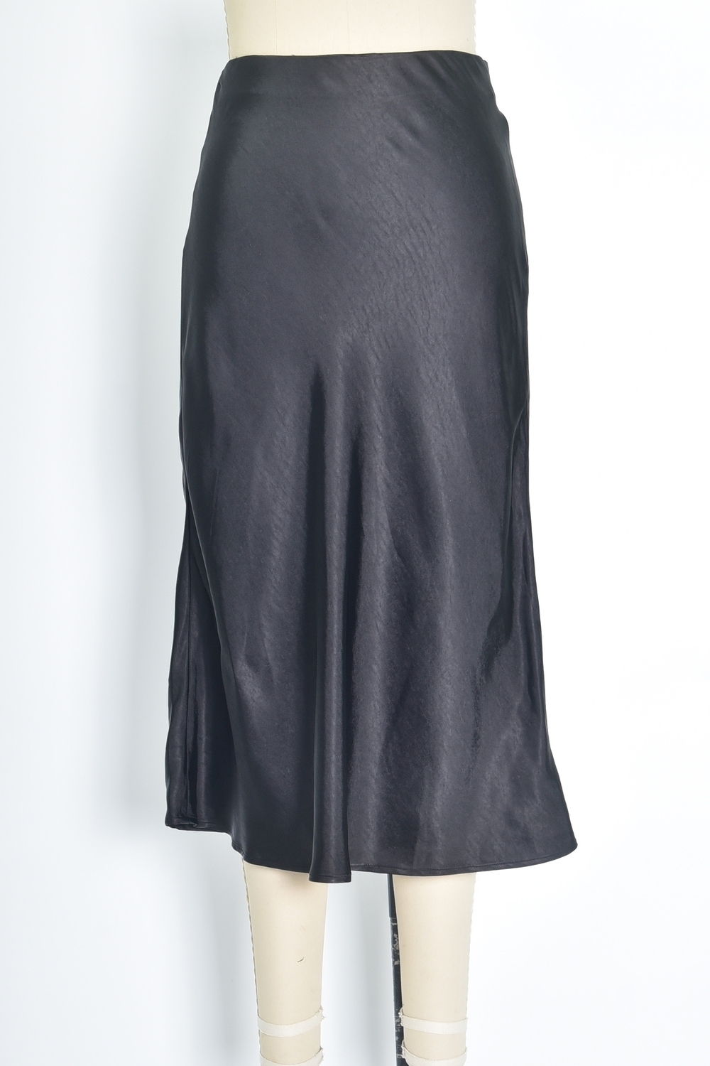 Réf. 41051 - Jupe longueur midi à la coupe évasée. Taille plate sans ceinture apparente pour un fini épuré. Matière satinée offrant un tombé souple et élégant. Fermeture discrète sur le côté.