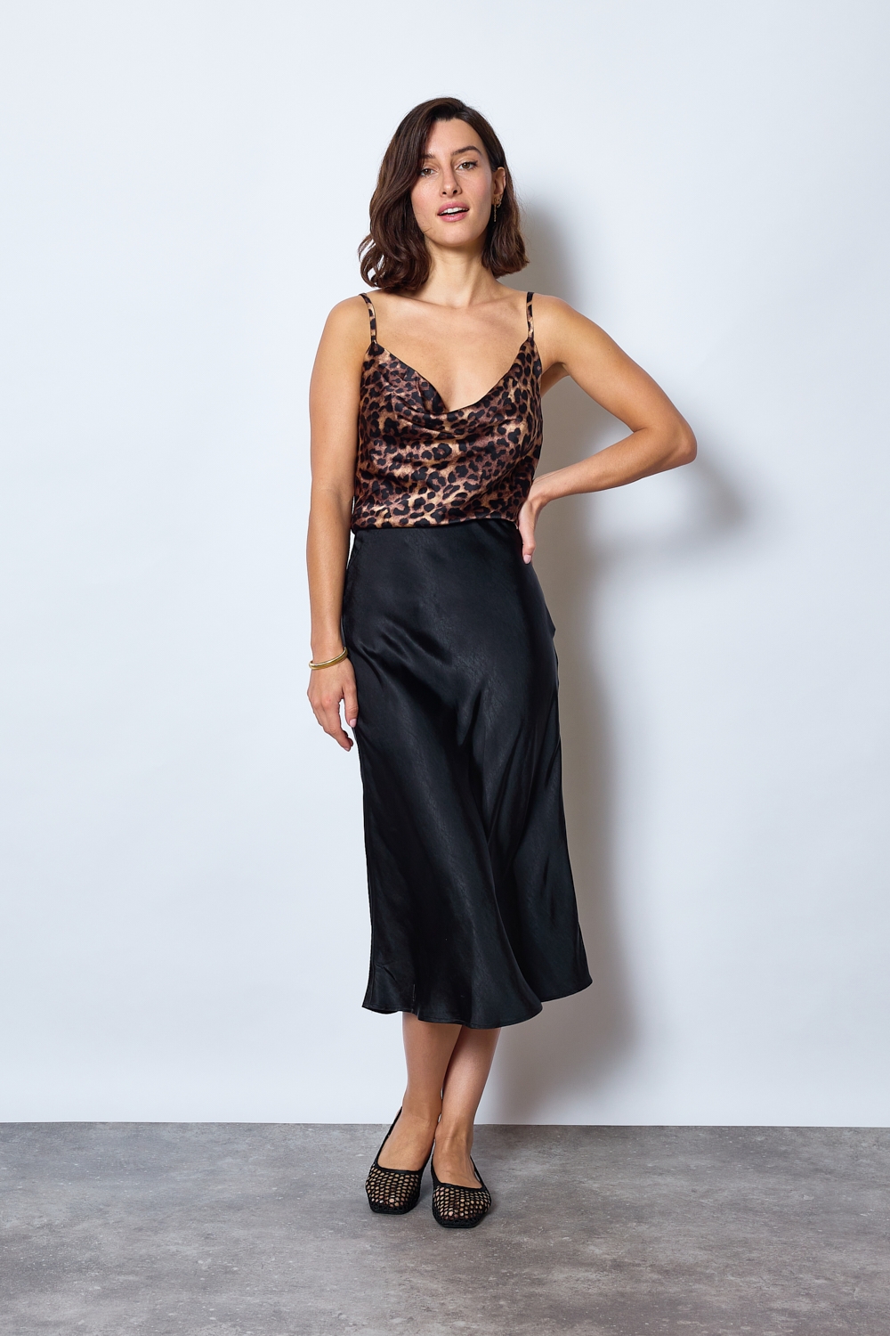 Réf. 41051 - Jupe longueur midi à la coupe évasée. Taille plate sans ceinture apparente pour un fini épuré. Matière satinée offrant un tombé souple et élégant. Fermeture discrète sur le côté.