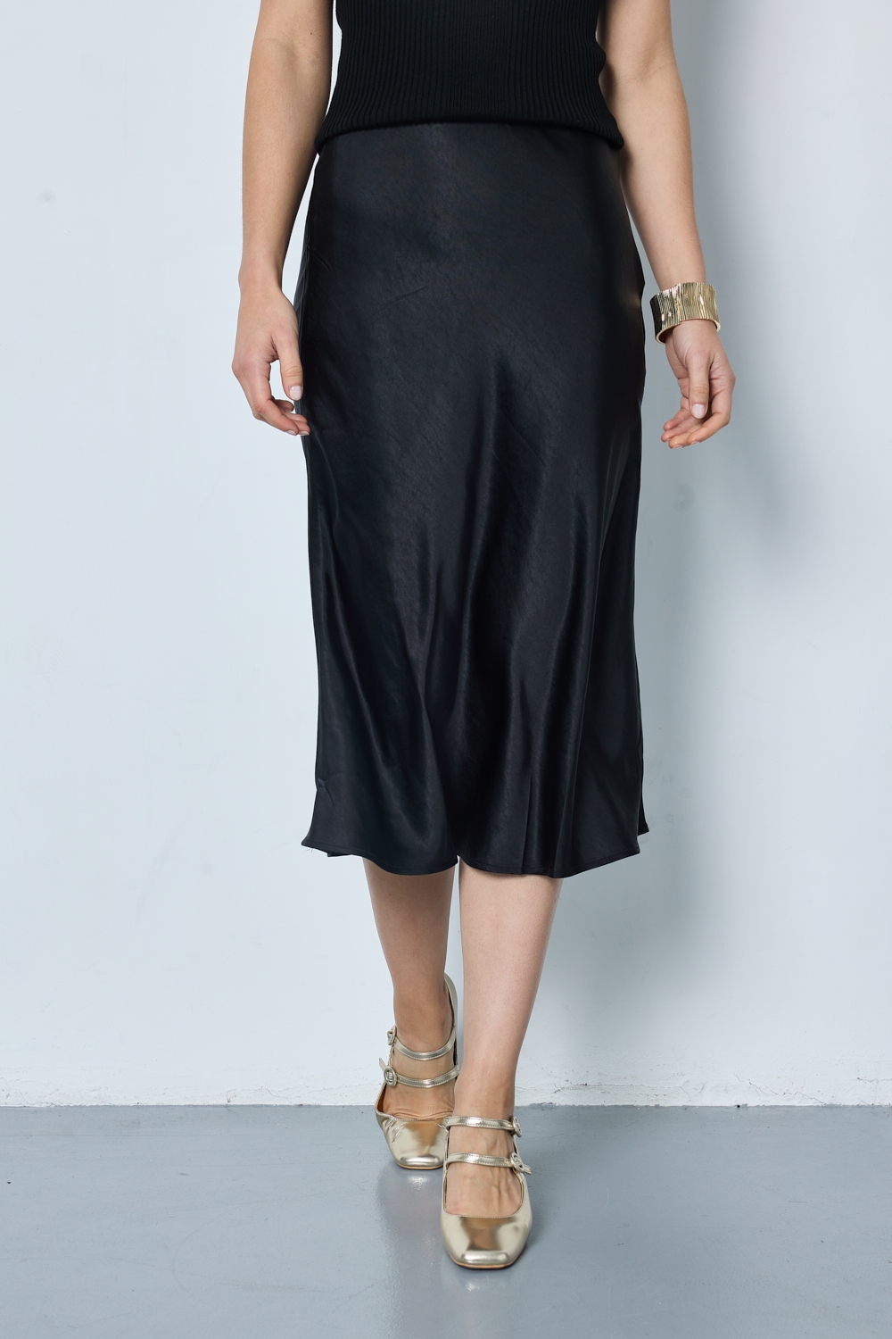 Réf. 41051 - Jupe longueur midi à la coupe évasée. Taille plate sans ceinture apparente pour un fini épuré. Matière satinée offrant un tombé souple et élégant. Fermeture discrète sur le côté.