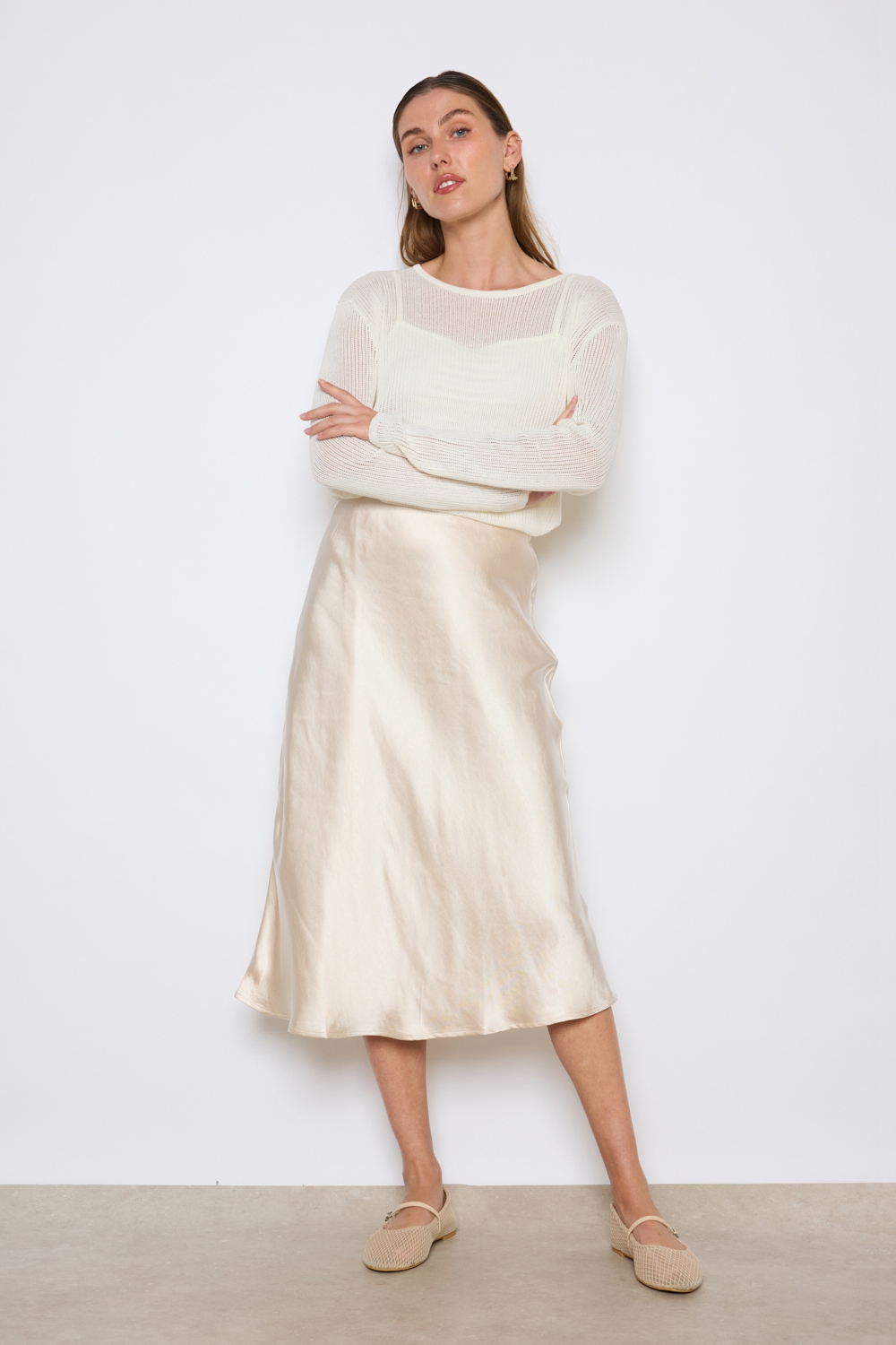 Réf. 41051A - Jupe longueur midi à la coupe évasée. Taille plate sans ceinture apparente pour un fini épuré. Matière satinée offrant un tombé souple et élégant. Fermeture discrète sur le côté.