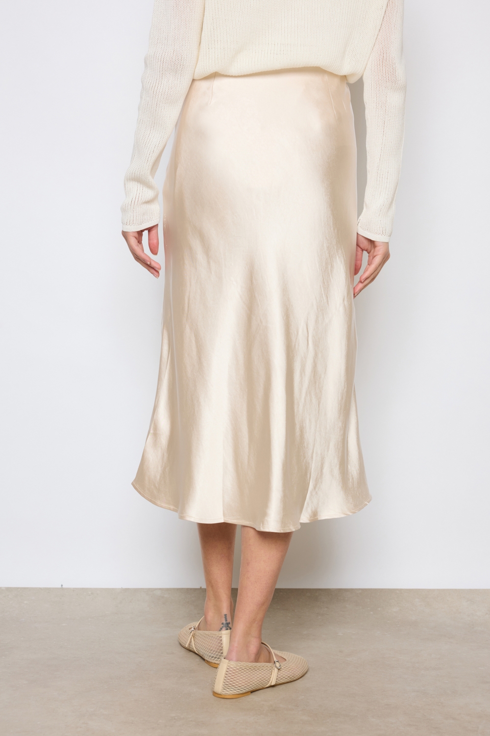 Réf. 41051A - Jupe longueur midi à la coupe évasée. Taille plate sans ceinture apparente pour un fini épuré. Matière satinée offrant un tombé souple et élégant. Fermeture discrète sur le côté.