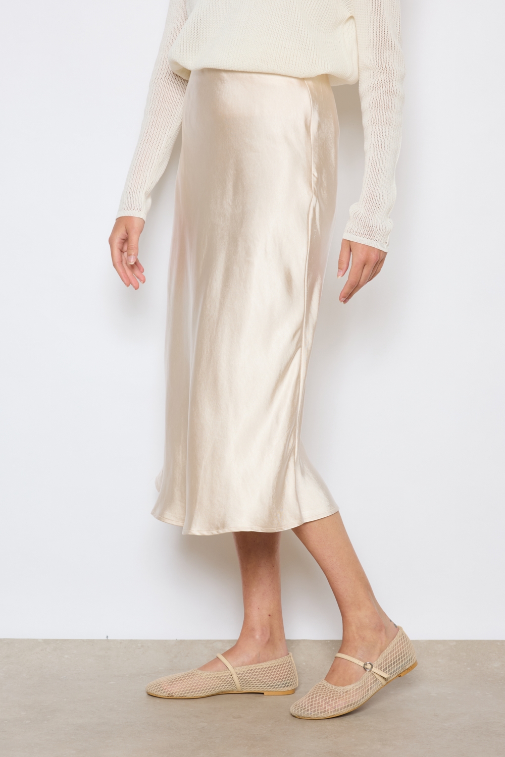 Réf. 41051A - Jupe longueur midi à la coupe évasée. Taille plate sans ceinture apparente pour un fini épuré. Matière satinée offrant un tombé souple et élégant. Fermeture discrète sur le côté.