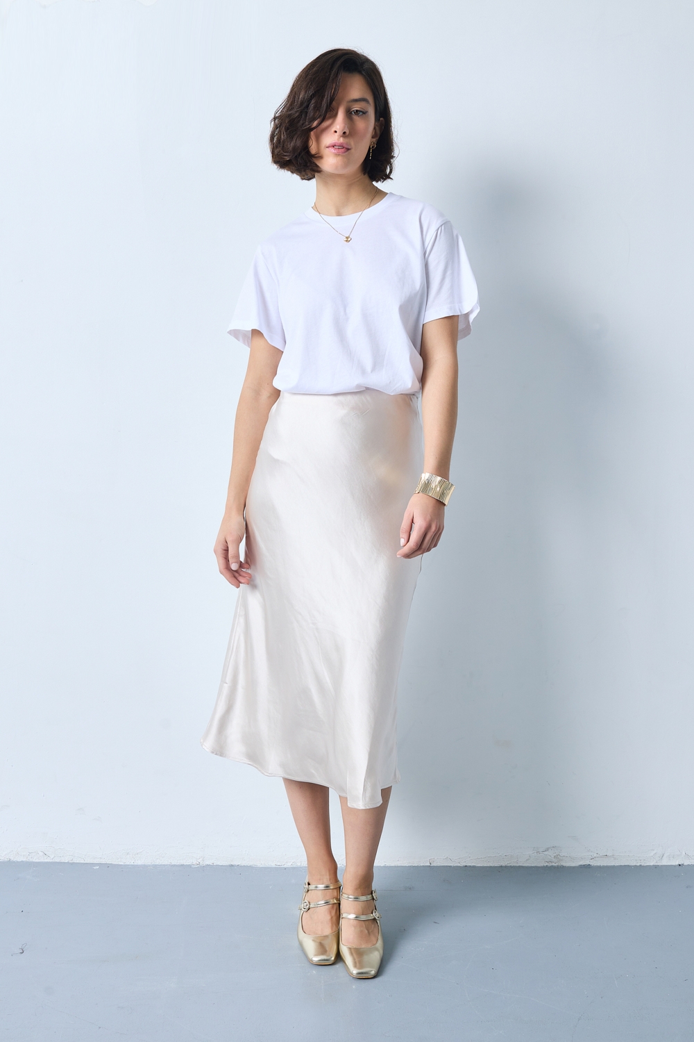 Réf. 41051A - Jupe longueur midi à la coupe évasée. Taille plate sans ceinture apparente pour un fini épuré. Matière satinée offrant un tombé souple et élégant. Fermeture discrète sur le côté.