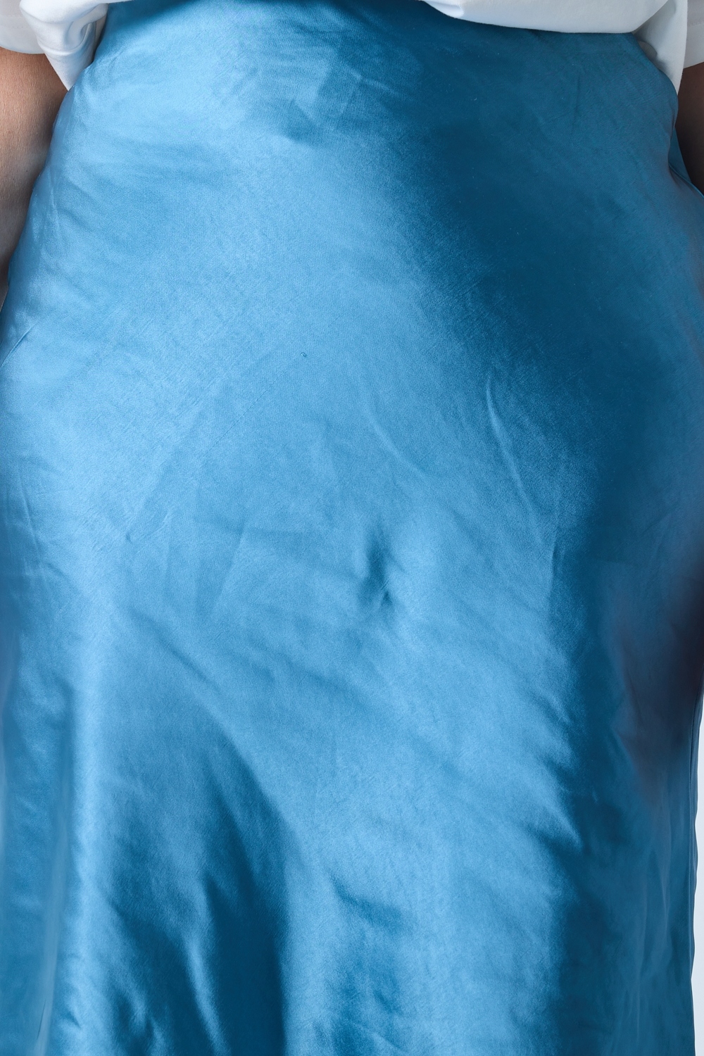 Réf. 41051B - Jupe longueur midi à la coupe évasée. Taille plate sans ceinture apparente pour un fini épuré. Matière satinée offrant un tombé souple et élégant. Fermeture discrète sur le côté.