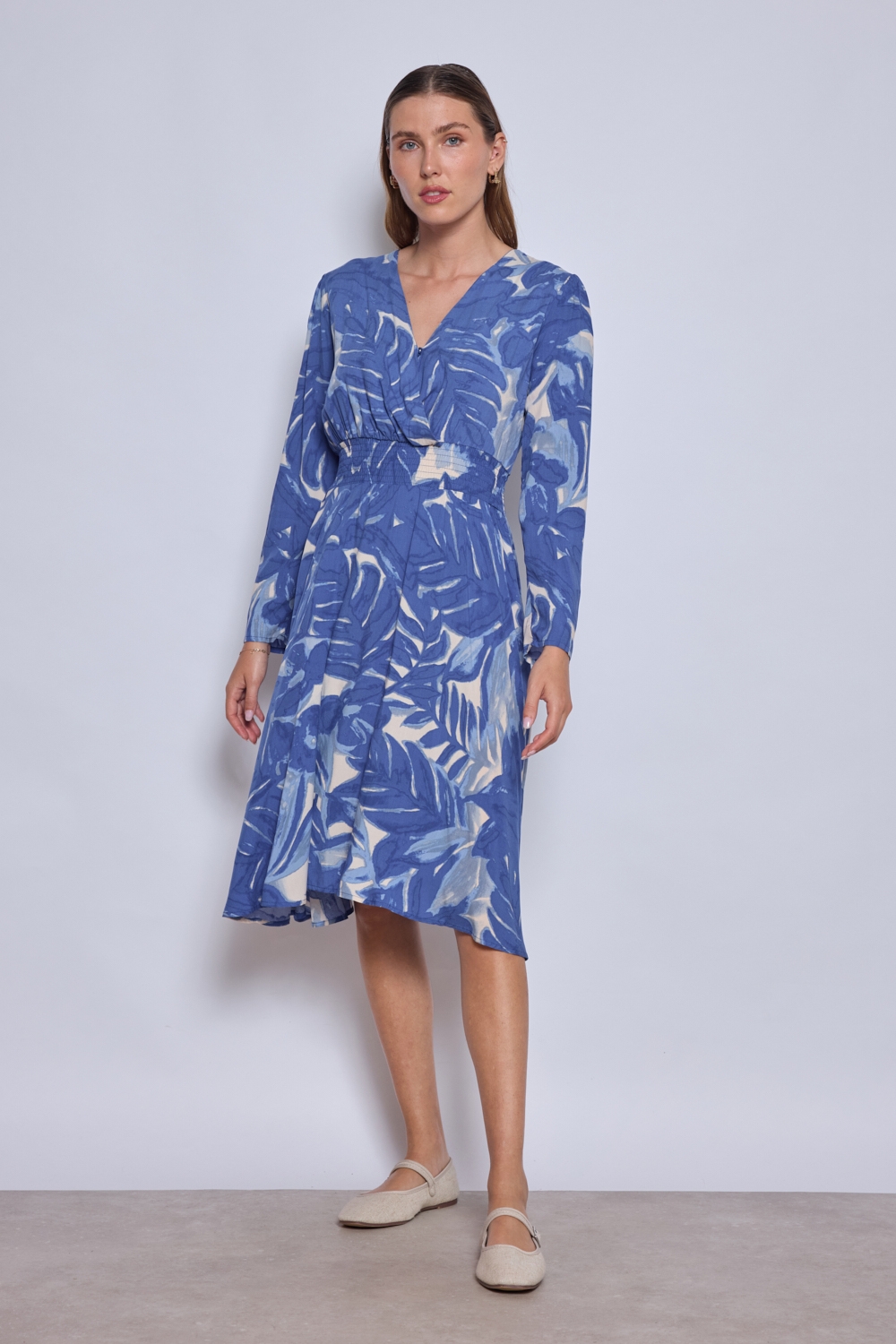 Réf. 47074 - Robe fluide avec encolure en V croisée et taille marquée par un élastique. Jupe évasée offrant un mouvement ample et léger. Finitions discrètes aux poignets et à l'ourlet.