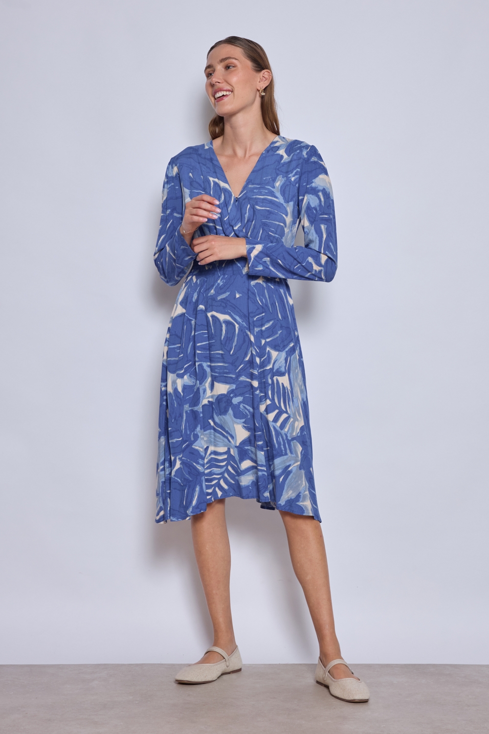 Réf. 47074 - Robe fluide avec encolure en V croisée et taille marquée par un élastique. Jupe évasée offrant un mouvement ample et léger. Finitions discrètes aux poignets et à l'ourlet.