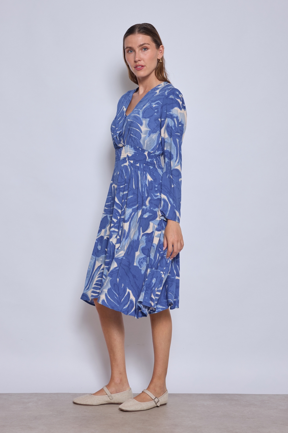 Réf. 47074 - Robe fluide avec encolure en V croisée et taille marquée par un élastique. Jupe évasée offrant un mouvement ample et léger. Finitions discrètes aux poignets et à l'ourlet.