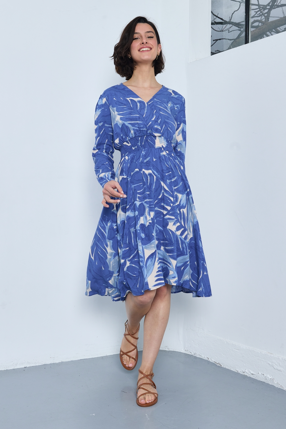 Réf. 47074 - Robe fluide avec encolure en V croisée et taille marquée par un élastique. Jupe évasée offrant un mouvement ample et léger. Finitions discrètes aux poignets et à l'ourlet.