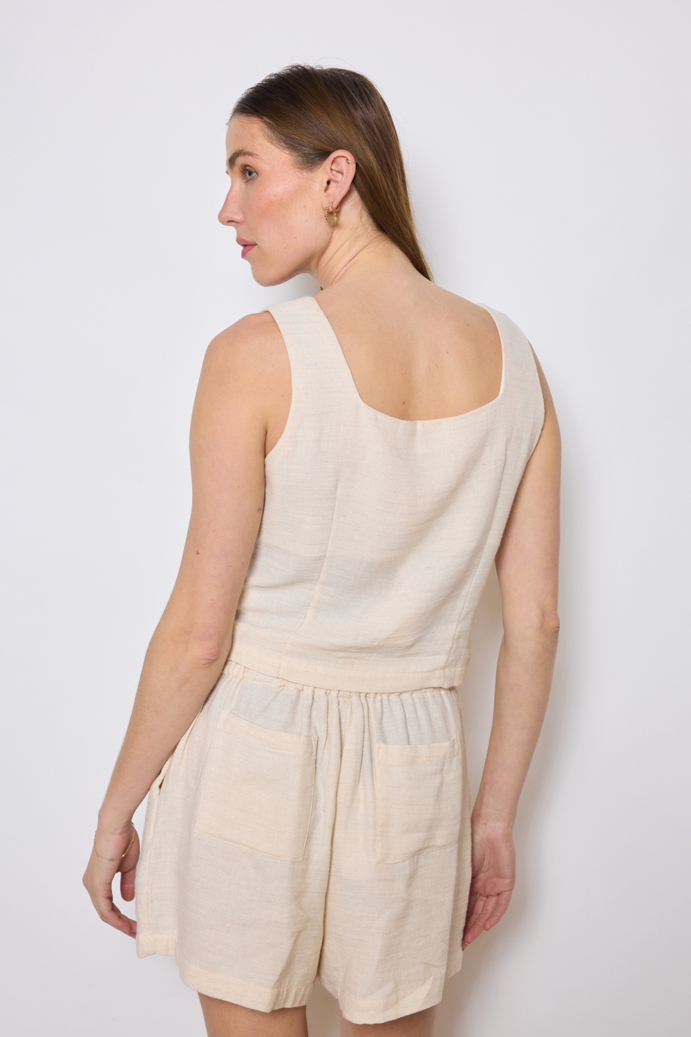 Réf. 47005 - Top ajusté avec encolure légèrement carrée et fermeture boutonnée sur le devant. Pinces discrètes pour une coupe structurée. Finition droite à la base.