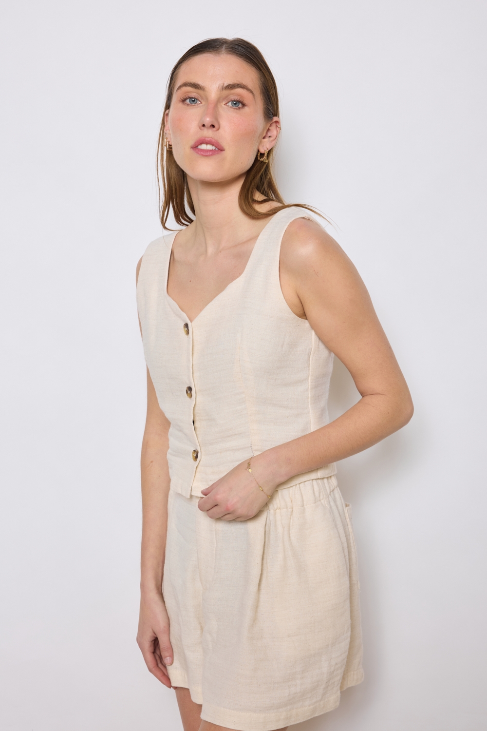 Réf. 47005 - Top ajusté avec encolure légèrement carrée et fermeture boutonnée sur le devant. Pinces discrètes pour une coupe structurée. Finition droite à la base.