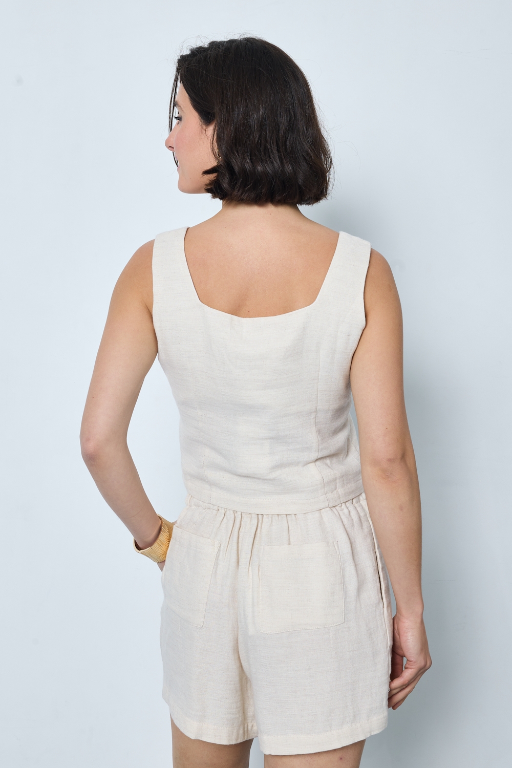 Réf. 47005 - Top ajusté avec encolure légèrement carrée et fermeture boutonnée sur le devant. Pinces discrètes pour une coupe structurée. Finition droite à la base.