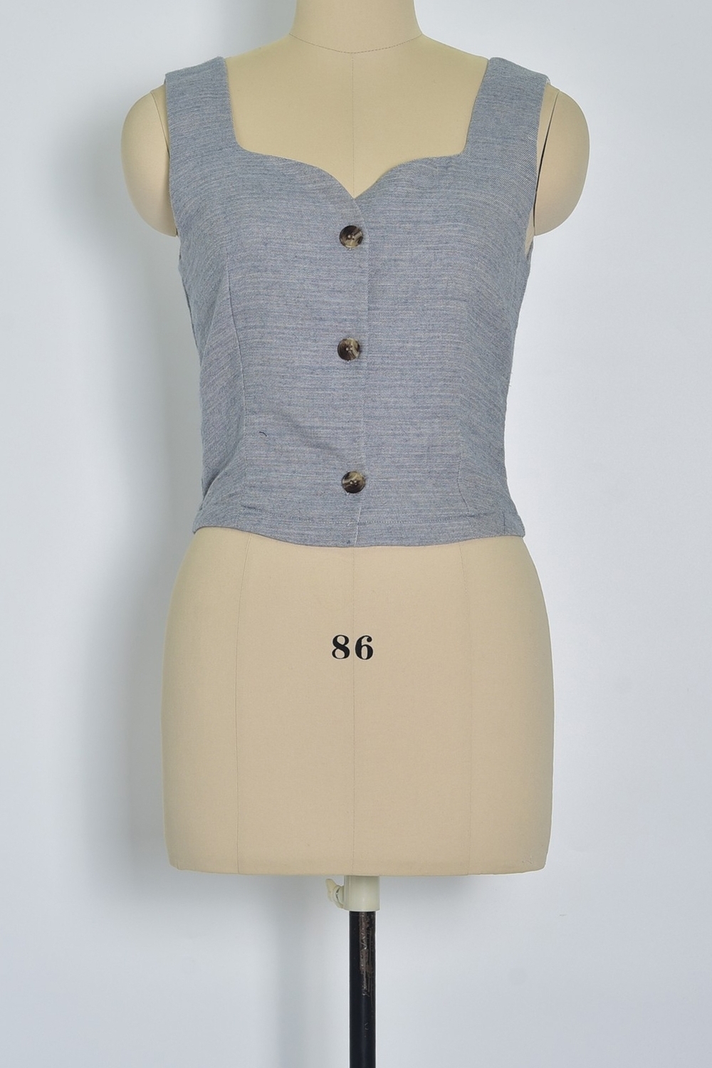 Réf. 47005A - Top ajusté avec encolure légèrement carrée et fermeture boutonnée sur le devant. Pinces discrètes pour une coupe structurée. Finition droite à la base.