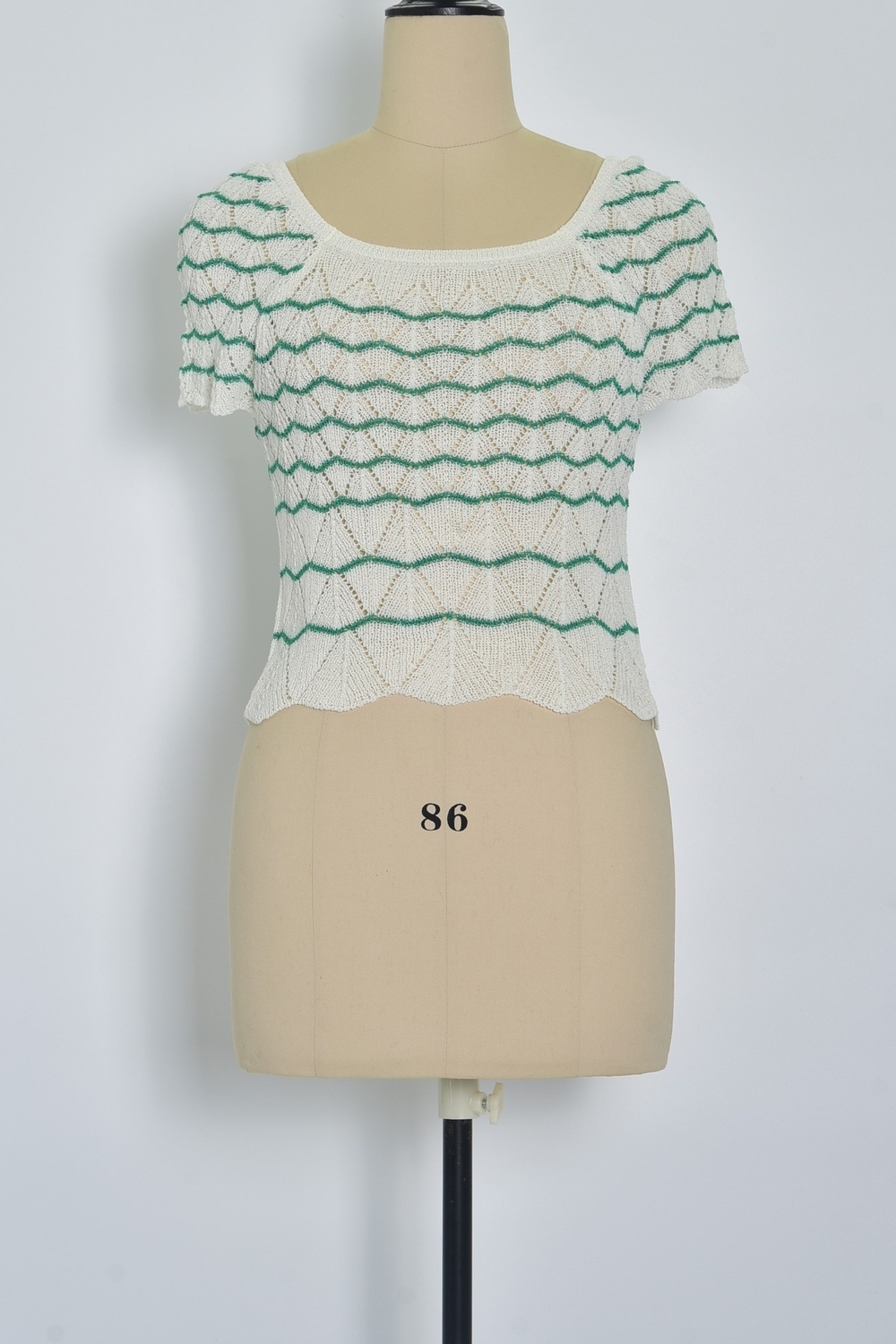 Réf. 47015 - Top ajusté avec encolure ronde dégagée et manches courtes. Tricot ajouré avec motifs en relief réguliers. Finition côtelée discrète à la base et aux manches.