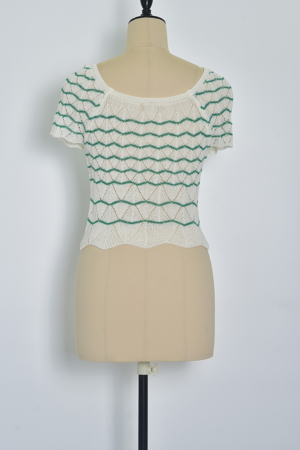 Réf. 47015 - Top ajusté avec encolure ronde dégagée et manches courtes. Tricot ajouré avec motifs en relief réguliers. Finition côtelée discrète à la base et aux manches.