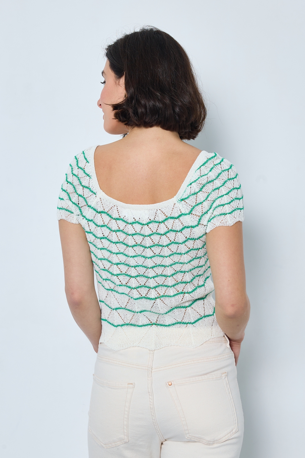 Réf. 47015 - Top ajusté avec encolure ronde dégagée et manches courtes. Tricot ajouré avec motifs en relief réguliers. Finition côtelée discrète à la base et aux manches.