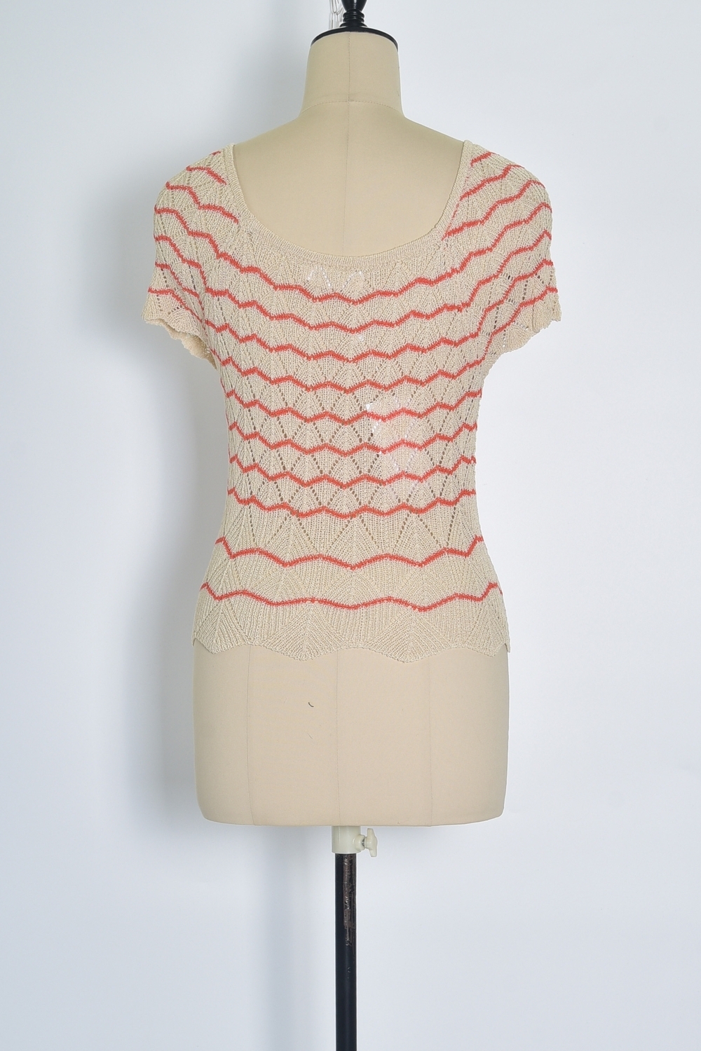 Réf. 47015A - Top ajusté avec encolure ronde dégagée et manches courtes. Tricot ajouré avec motifs en relief réguliers. Finition côtelée discrète à la base et aux manches.