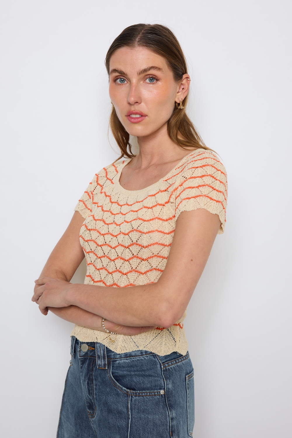 Réf. 47015A - Top ajusté avec encolure ronde dégagée et manches courtes. Tricot ajouré avec motifs en relief réguliers. Finition côtelée discrète à la base et aux manches.