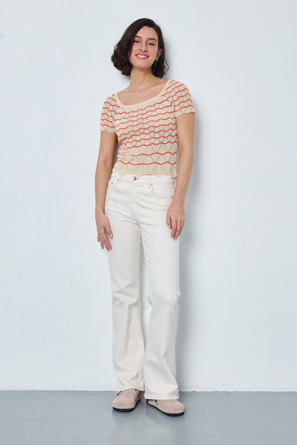 Réf. 47015A - Top ajusté avec encolure ronde dégagée et manches courtes. Tricot ajouré avec motifs en relief réguliers. Finition côtelée discrète à la base et aux manches.