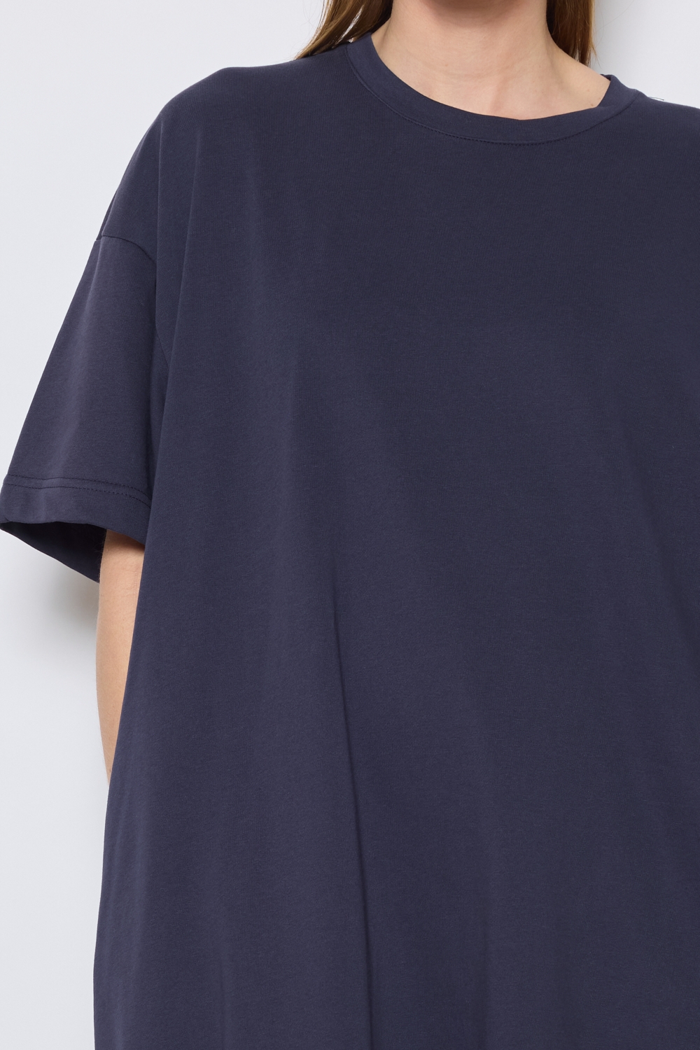Réf. 43015B - Robe t-shirt de couleur marine. La robe a des manches courtes, une encolure ronde, poches sur les côtés et une coupe droite qui tombe de manière décontractée sur le corps. Sa simplicité est soulignée par l'absence de motif ou de détails superflus, ce qui en fait une pièce versatile qui pourrait être accessoirisée de diverses manières.