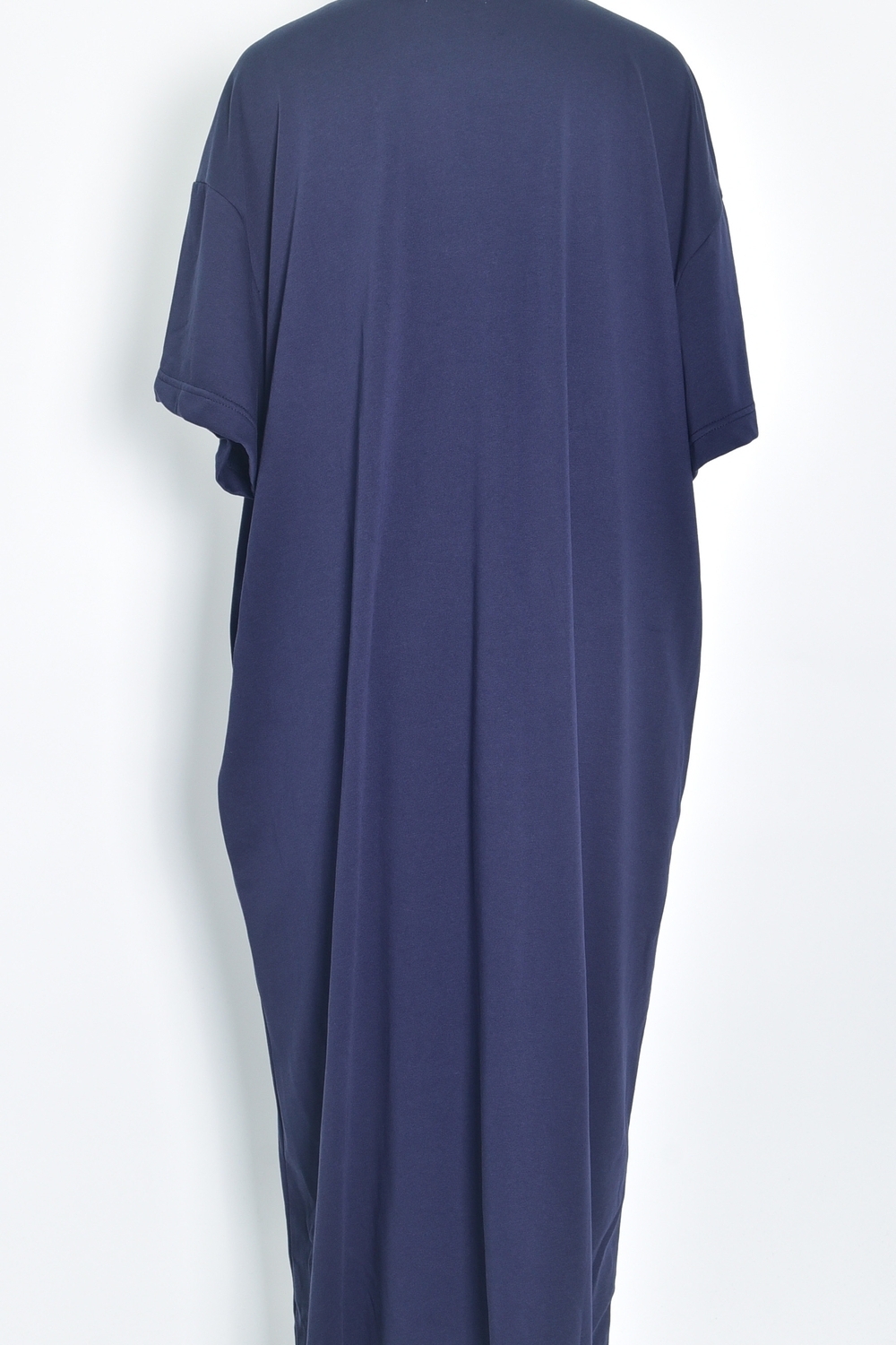 Réf. 43015B - Robe t-shirt de couleur marine. La robe a des manches courtes, une encolure ronde, poches sur les côtés et une coupe droite qui tombe de manière décontractée sur le corps. Sa simplicité est soulignée par l'absence de motif ou de détails superflus, ce qui en fait une pièce versatile qui pourrait être accessoirisée de diverses manières.